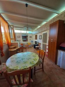 切萨雷奥港2 bedrooms property with shared pool at Porto Cesareo 1 km away from the beach的厨房以及带桌椅的用餐室。
