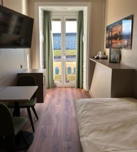 卢塞恩匹克威克酒店及酒馆“看得见风景的客房”的配有一张床、一张书桌和一扇窗户的酒店客房