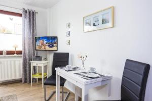 青斯特Ostseeliebe, gemütliche und moderne Ferienwohnung für 2 Personen in Zingst的一间设有白色书桌和两把椅子的房间