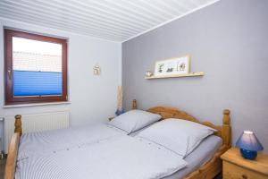 青斯特Ostseeliebe, gemütliche und moderne Ferienwohnung für 2 Personen in Zingst的一间卧室设有一张床和一个窗口