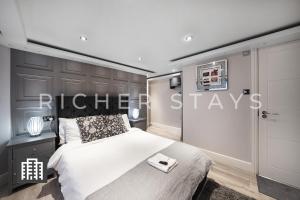 伦敦Hackney Suites - En-suite rooms & amenities的一间卧室,配有一张床和一个读电的标志