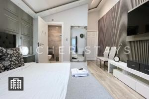 伦敦Hackney Suites - En-suite rooms & amenities的一间带大床的卧室和一间浴室