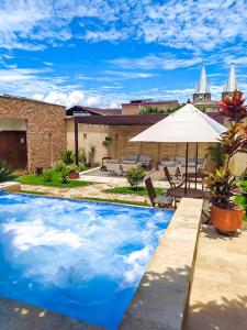 贾丁Casa Passiflora Hotel Boutique的一个带遮阳伞的游泳池和庭院