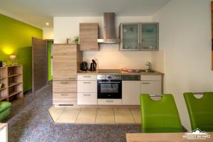 韦尼格罗德Auszeit-im-Harz Haus 6 Wohnung 3的一间拥有白色橱柜和绿色装饰的厨房
