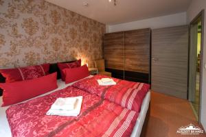 韦尼格罗德Auszeit-im-Harz Haus 6 Wohnung 3的一间卧室配有红色的床和2条毛巾