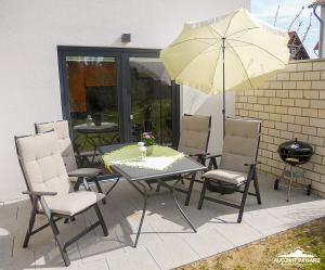 韦尼格罗德Auszeit-im-Harz Haus 6 Wohnung 3的庭院内桌椅和遮阳伞