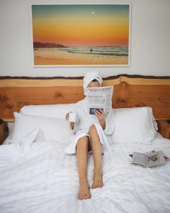 托菲诺太平洋金沙海滩度假村 的躺在床上看报纸的人