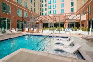 格林维尔SpringHill Suites by Marriott Greenville Downtown的大楼内带椅子的大型游泳池
