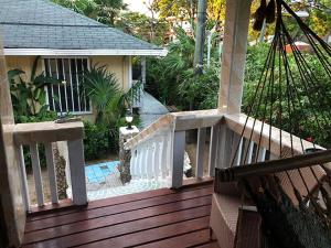 西区Coconut Tree West End的房屋上带白色栏杆的木甲板