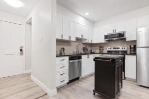 渥太华14 minutes from downtown, brand new home in Ottawa的厨房配有白色橱柜和黑色冰箱。