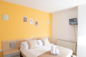 锡古恩萨Hostal-Casa Rural Rosa-Nonna的卧室配有白色床和黄色墙