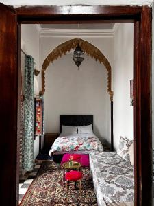 拉巴特Riad Palais D'Or的一间卧室配有一张床和一张红色椅子