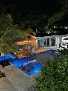 瓜鲁雅Pousada Village Cozumel的夜间游泳池与房子