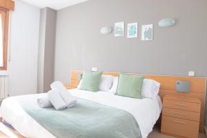 锡古恩萨Hostal-Casa Rural Rosa-Nonna的一间卧室配有两张带白色和绿色枕头的床