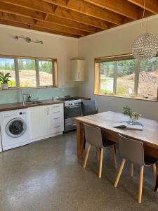 TasmanBeech Hill - Pet Friendly Holiday Home的一间带木桌的厨房和一间餐厅
