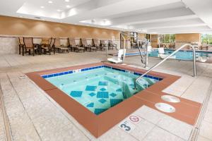 费尔班克斯费尔班克斯汉普顿酒店及套房的一个带椅子和桌子的酒店游泳池