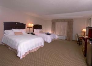 法明顿Hampton Inn & Suites Farmington的酒店客房设有两张床和电视。