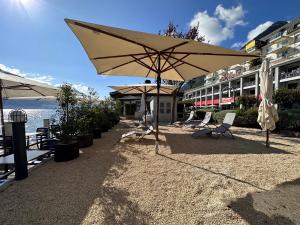 盖尔绍Seehotel Riviera at Lake Lucerne的一座带椅子和遮阳伞的庭院位于大楼旁