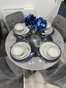 奥尔德肖特Blue Madison的一张桌子,上面有盘子和一花瓶,