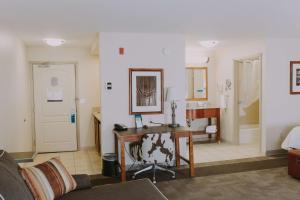 格林里弗绿河汉普顿酒店及套房的一间带书桌的客厅和一间浴室。