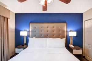 休斯顿休斯顿宁静商业街惠庭套房酒店的一间卧室设有一张蓝色墙壁的大床