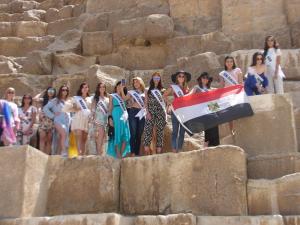 开罗Egypt Pyramids Hotel的一群站在石墙上,挂着旗帜的妇女