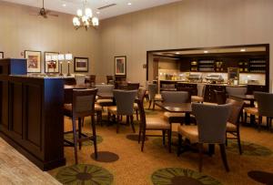 克拉尔维尔希尔顿科洛威尔郝伍德套房 - 艾瓦瑞沃兰德酒店的一间带桌椅的餐厅和一间酒吧
