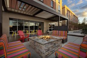 杰克逊维尔Home2 Suites by Hilton Jacksonville, NC的一座建筑中带椅子和火坑的庭院