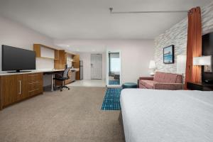 杰克逊维尔Home2 Suites by Hilton Jacksonville, NC的配有一张床和一张书桌的酒店客房