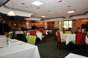 费耶特维尔费耶特维尔希尔顿逸林酒店的用餐室配有白色的桌子和绿色的椅子