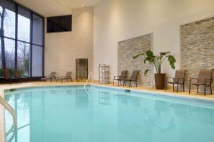 萨默塞特萨默塞特希尔顿逸林酒店及行政会议中心的一座带椅子和桌子的酒店游泳池