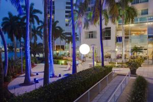 劳德代尔堡GALLERY One - A DoubleTree Suites by Hilton Hotel的棕榈树庭院和建筑
