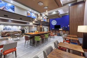 休斯顿乔治·布什洲际机场汉普顿套房酒店的一间带桌椅的餐厅和一间酒吧