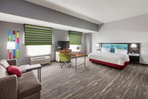 休斯顿乔治·布什洲际机场汉普顿套房酒店的配有一张床和一张书桌的酒店客房