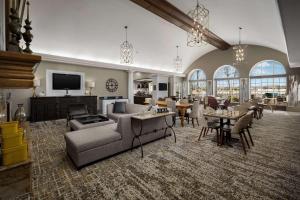 威奇托海滨希尔顿惠庭套房酒店的客厅配有沙发、椅子和电视