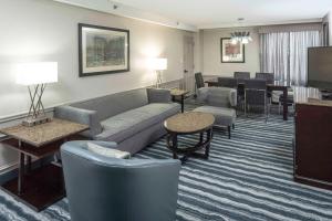 威尔明顿DoubleTree by Hilton Hotel Wilmington的酒店客房设有沙发和椅子,还有一间起居室。