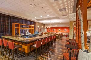 休斯顿休斯顿市中心希尔顿惠庭套房酒店的餐厅内的酒吧,带红色椅子