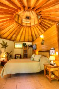 SaraotouExclusive Sunrise Eco Resort的一间卧室设有一张带木制天花板的大床