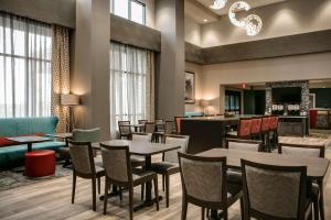 威奇托Hampton Inn By Hilton Wichita Northwest的一间带桌椅的餐厅和一间酒吧