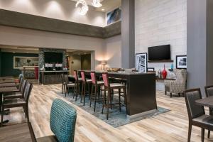 威奇托Hampton Inn By Hilton Wichita Northwest的餐厅设有酒吧,配有椅子和桌子