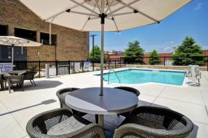 格林维尔Homewood Suites By Hilton Greenville Downtown的一个带桌椅的庭院和一个游泳池