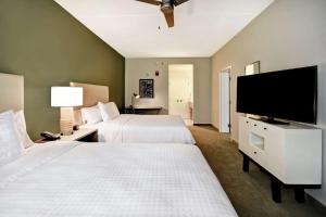 格林维尔Homewood Suites By Hilton Greenville Downtown的酒店客房设有两张床和一台平面电视。