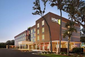 费南迪纳比奇Home2 Suites By Hilton Fernandina Beach on Amelia Island, FL的一座酒店大楼,上面有家庭仓库标志