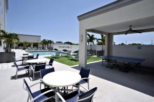 达尼亚滩Hotel Dello Ft Lauderdale Airport, Tapestry Collection by Hilton的游泳池旁带桌椅的天井