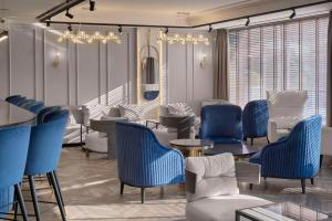 普罗夫迪夫Hotel Imperial Plovdiv, a member of Radisson Individuals的一间设有蓝色椅子和桌子的等候室