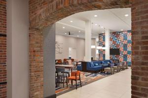 印第安纳波利斯Homewood Suites by Hilton Indianapolis Downtown IUPUI的开放式的大堂设有砖墙和椅子