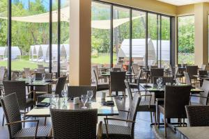 科纳卡美哈美哈国王科纳海滩万豪酒店的用餐室设有桌椅和窗户。