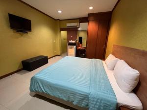 乌隆他尼จินตคามโฮมเพลส/Jintakam Home Place的一间卧室配有一张带蓝色床单的床和电视。