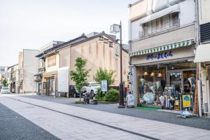 金泽ゲストルーム心音-金澤表参道-的城市里一条空荡荡的街道,有商店