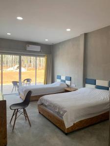 Kaki Bukit365 View Point Resort的一间卧室设有两张床、一把椅子和一个窗户。